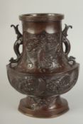 AN UNUSUAL BRONZE TWIN HANDLE DRAGON AND PHOENIX VASE, with panels of relief decoration including