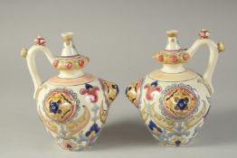 A PAIR OF 19TH CENTURY ORIENTALIST HUNGARIAN ZSOLNAY PORCELAIN JUGS, 17cm high.