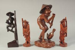 A CARVED HARDWOOD FIGURE, 30cm high, together with three other carved wood figures, (4).