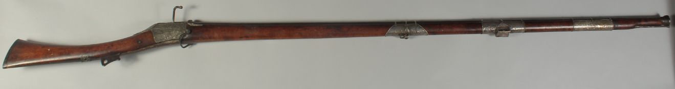 A 17TH CENTURY TURKISH OTTOMAN MATCHLOCK CASTLE RIFLE, with heavy ribbed barrel and silver bands and
