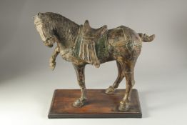 A LARGE CHINESE TANG STYLE POTTERY HORSE, mounted to a wooden base, 50cm long.