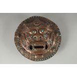 A 19TH CENTURY TIBETAN COPPER INCENSE BURNER WALL MASK, inset with turquoise beads, 24cm diameter.