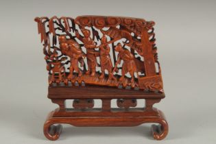 A FINE CHINESE CARVED AND PIERCED WOOD FIGURAL GROUP, mounted with two pegs to a fitted hardwood