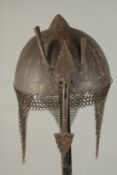 A PERSIAN QAJAR GOLD INLAID STEEL HELMET, with retractable nose guard flanked by two plume