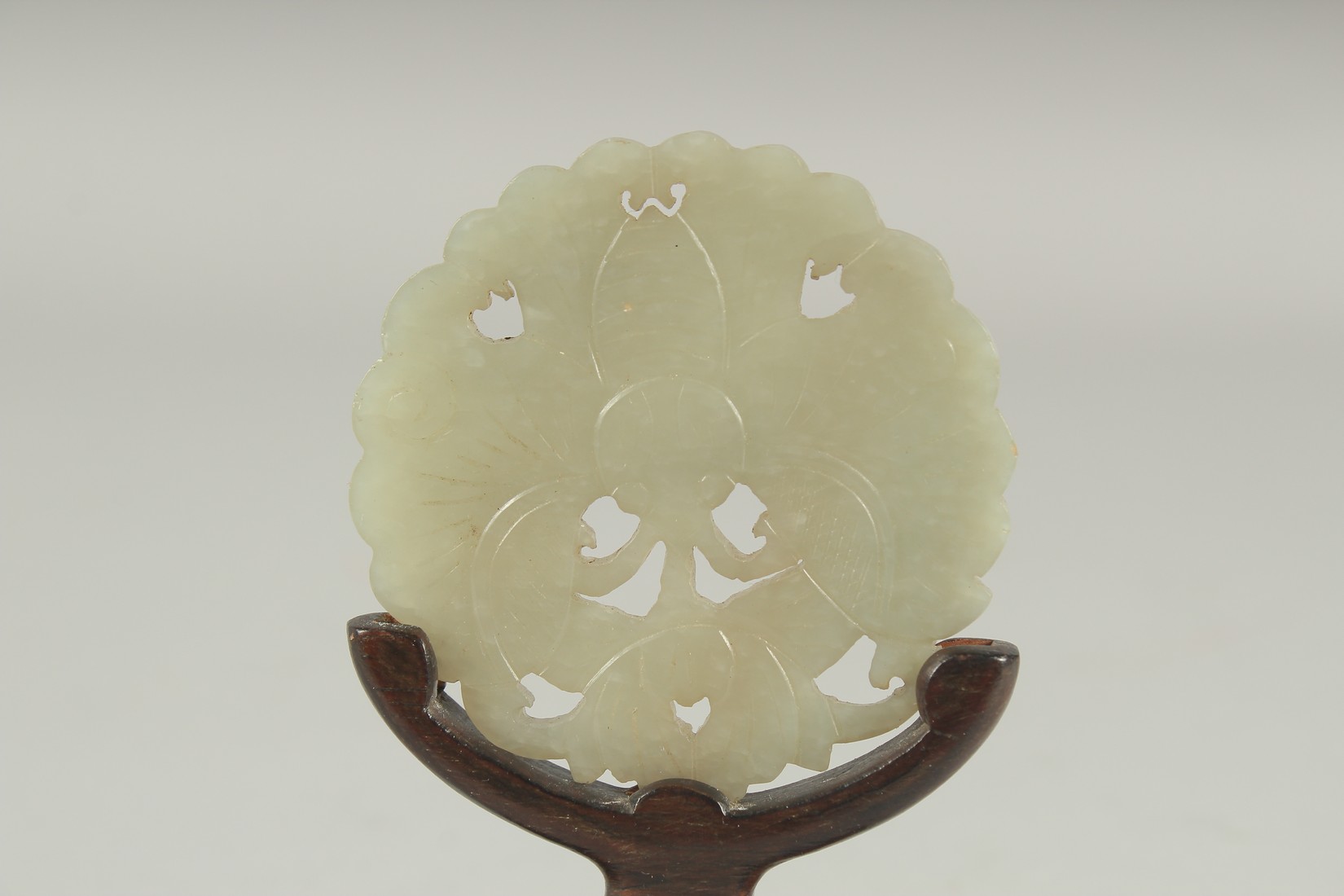 A CHINESE CARVED AND PIERCED JADE MOTH AMULET, on a fitted wooden stand, 6cm diameter. - Image 3 of 3