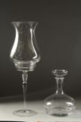 A TALL PLAIN CLASS STORM LAMP ON STAND. 18ins high and a plain ships decanter and stopper.