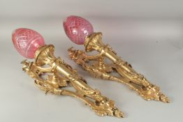 A GOOD PAIR OF GILT BRONZE CORNET WALL SCONCES with cranberry glass shades. 2ft 3ins high.