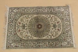 A SMALL PERSIAN PART SILK RUG green ground with an all over floral design. 3ft x 2ft.