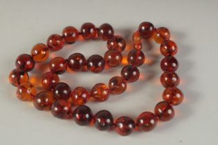 AN AMBER NECKLACE OF THIRTY TWO BEADS.
