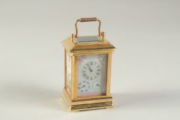 A MINIATURE "SEVRES" STYLE CARRIAGE CLOCK with porcelain dial and panels. 3.75ins high including