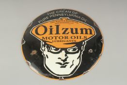 A CIRCULAR TIN SIGN " OILZUN MOTOR OILS". 11ins diameter.
