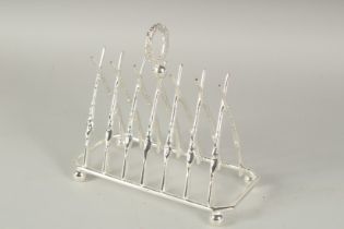 A CHRISTOPHER DRESSER STYLE SILVER PLATED CROSSED GUNS TOAST RACK.
