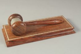 AN AUCTIONEERS WOODEN GAVEL AND STAND.