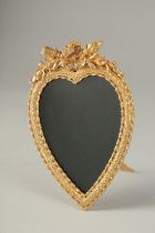 A GILT METAL HEART SHAPE STRUT PHOTOGRAPH FRAME. 7ins high.