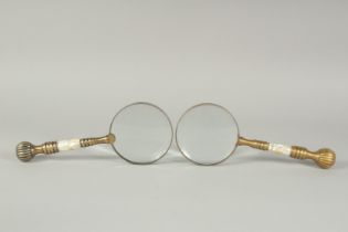 A PAIR OF BRASS AND MOTHER OF PEARL MAGNIFYING GLASSES.