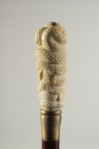 A CARVED BONE HANDLE WALKING STICK "SNAKE". 2ft 11ins long.