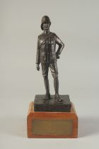 A SPELTER FIGURE OF A SOLDIER on a wooden base. 9ins high.