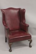 A GOOD STUDDED LEATHER WING ARM CHAIR on claw and ball feet.