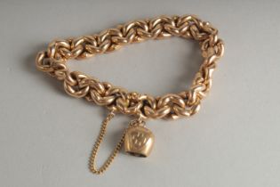 A 15CT GOLD CHAIN LINK BRACELET and a charm. Weight: 28.9gms.
