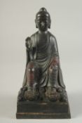 A BRONZE MODEL OF A SEATED BUDDHA one arm raised with traces of painted decoration. 9ins high.