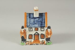 A PRATT WARE POTTERY HOUSE with blue roof, two men standing at the side of the house. 4.5ins high.