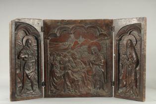 A VERY EARLY, POSSIBLY GERMAN ,CARVED OAK TRIPTYCH. The centre panel, 19ins x 17ins, Christ and