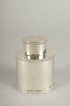 AN OVAL SILVER TEA CADDY. London 1915.