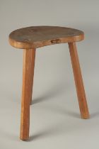 A GOOD MOUSEMAN OAK STOOL with kidney shaped top, on three legs. 18ins high.