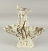 A WHITE BISQUE SHELL GROUP, a young girl with a fish, on a circular base. 1ft 5ins high.