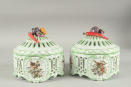 A PAIR OF SEVRES DESIGN CIRCULAR PIERCED PORCELAIN POTS AND COVERS with panels of flowers and