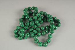 A STRING OF EIGHTY MALACHITE BEADS. 30ins long.