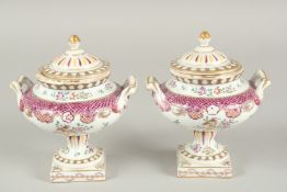 A SMALL PAIR OF SAMSON OF PARIS TWO HANDLED URNS AND COVERS with famille rose decoration and flowers