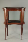 A GOOD MAHOGANY KIDNEY SHAPED BIJOUTERIE CABINET with glass sides and glass door, opening to