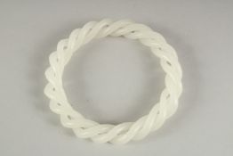 A WHITE JADE TWIST BANGLE. 3ins diameter.