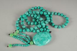 A STRING OF ONE HUNDRED TURQUOISE BEADS AND PENDANT. 20ins long overall.