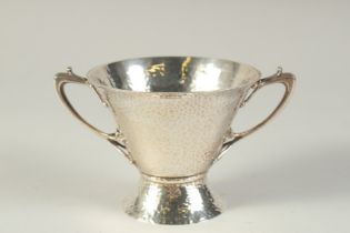 AN ART DECO HAMMERED TWO HANDLED SILVER BOWL. 4.5ins diameter, London 1904, maker: W.K.S. Weight: