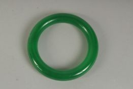 AN APPLE GREEN JADE BANGLE. 3ins diameter.