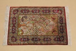 A SMALL PERSIAN PART SILK RUG cream ground with red ground border, "Tree of Life" design. 3ft 1ins x