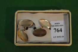 A pair of 9 carat gold oval shaped cufflinks with engine turned decoration.