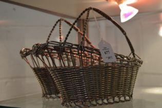 A pair of plated wine bottle pouring baskets.