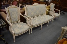 A Victorian style painted and upholstered three piece salon suite comprising three seater settee and