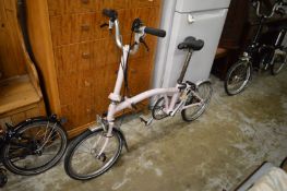 A good Brompton pink painted folding bicycle.