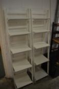A pair of white painted folding five tier display shelves.