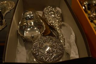 A silver sauce boat and silver backed dressing table items.