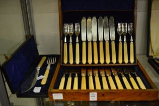 An oak cased set of twelve fish knives and forks with silver blades and tines together with a