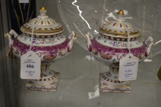 A pair of Paris porcelain urn shaped vases and covers.