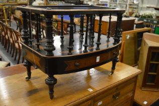 A Victorian ebonised and figured walnut three division bow fronted Canterbury.