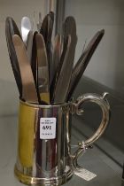 A plated tankard and a quantity of knives.