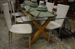 A stylish glass rectangular dining table with oak X shaped supports.