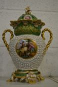 A large Continental porcelain twin handled urn and cover decorated with panel of figures with